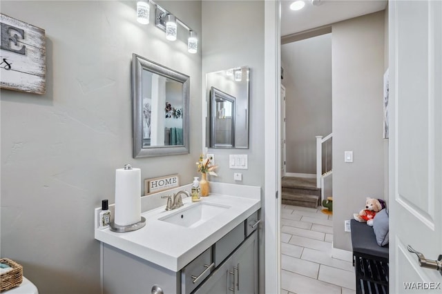 half bathroom featuring tile patterned flooring and vanity