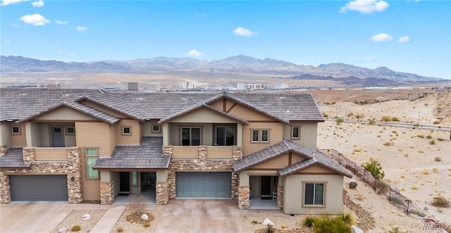 view of front of home with stone siding, driveway, and a mountain view