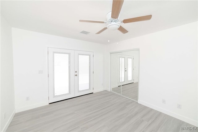 unfurnished room featuring french doors, visible vents, light wood-style flooring, ceiling fan, and baseboards