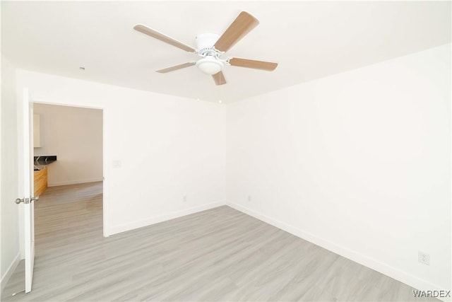 unfurnished room featuring light wood-style floors, baseboards, and a ceiling fan