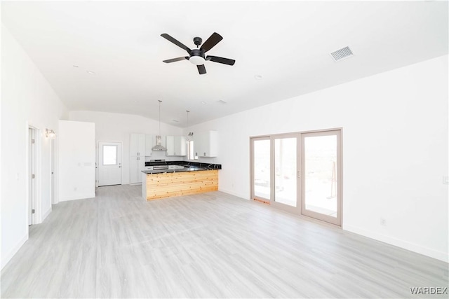 unfurnished living room with light wood-type flooring, ceiling fan, visible vents, and baseboards