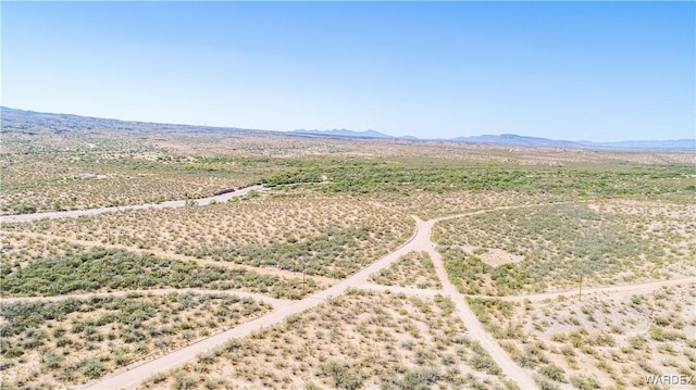 drone / aerial view featuring a desert view and a mountain view