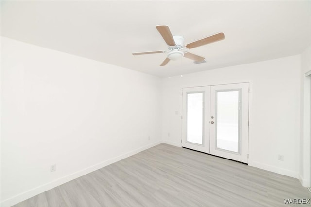 spare room featuring ceiling fan, light wood-style flooring, visible vents, baseboards, and french doors