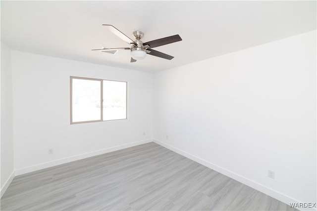 empty room with ceiling fan, light wood-style flooring, and baseboards