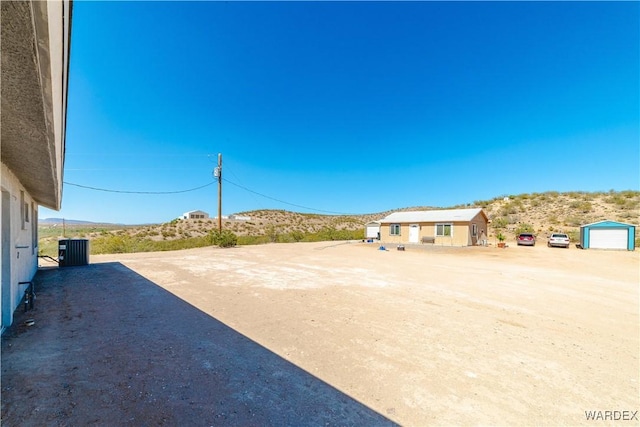 exterior space featuring driveway, a mountain view, and central AC