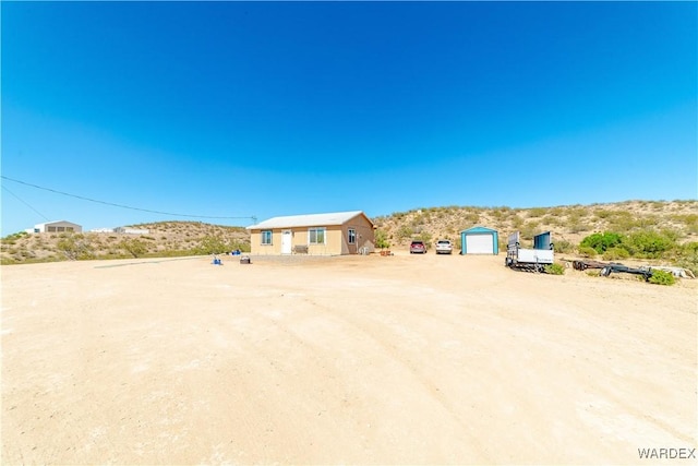 view of yard with dirt driveway and a detached garage