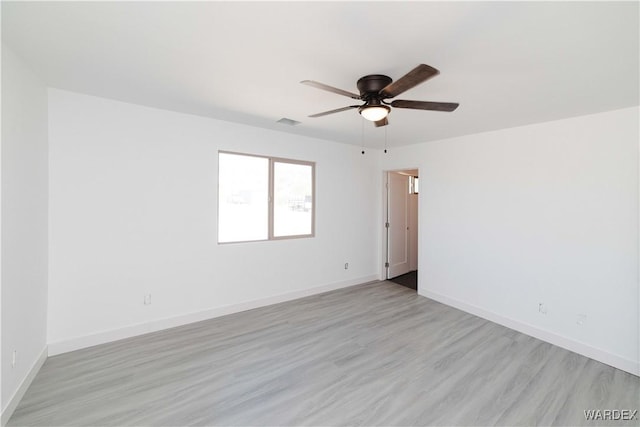 empty room with visible vents, ceiling fan, light wood-style flooring, and baseboards