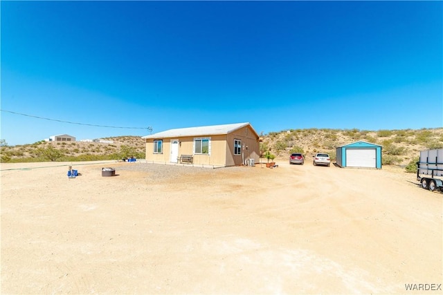 exterior space with driveway and a detached garage