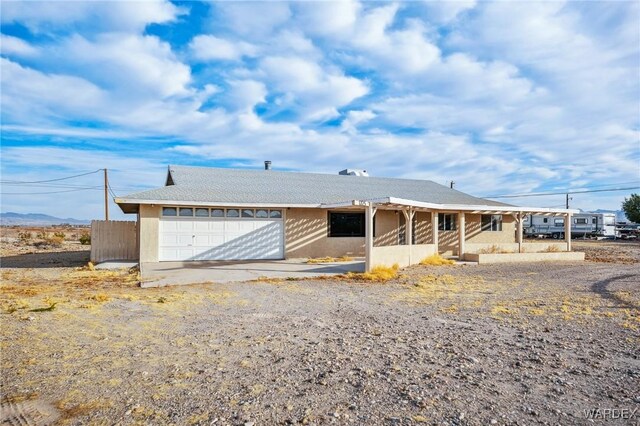 ranch-style home with a garage and fence