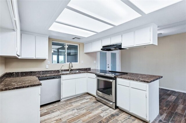 kitchen featuring appliances with stainless steel finishes, white cabinets, and under cabinet range hood