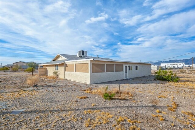 view of front of home featuring central air condition unit, fence, and stucco siding