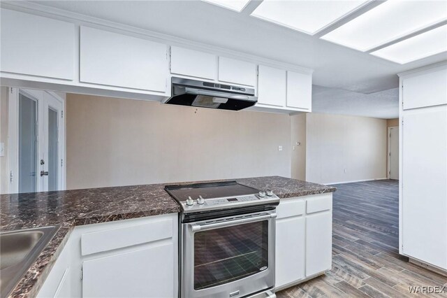 kitchen with wood finished floors, stainless steel electric range, under cabinet range hood, white cabinetry, and a sink