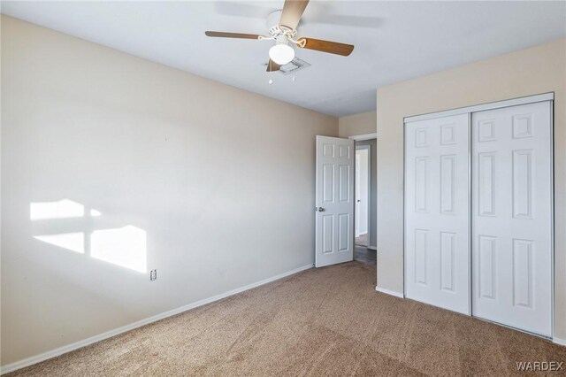 unfurnished bedroom featuring carpet floors, a closet, visible vents, ceiling fan, and baseboards