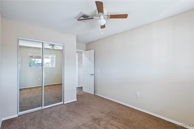 unfurnished bedroom with carpet floors, visible vents, baseboards, and a closet