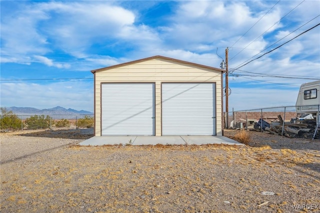 detached garage with a mountain view and fence