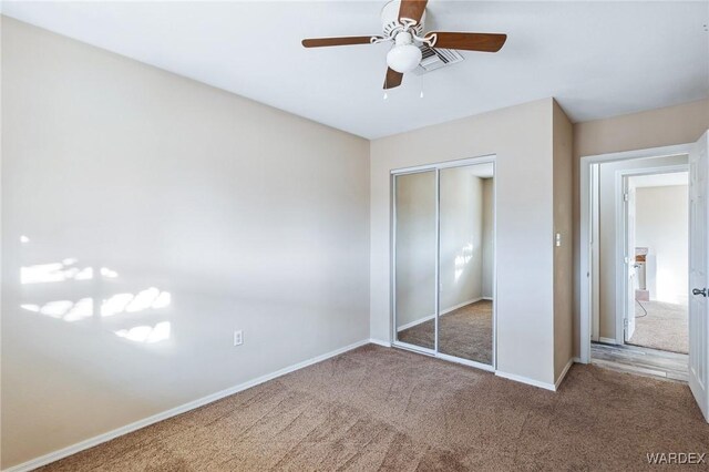 unfurnished bedroom with carpet floors, a ceiling fan, visible vents, baseboards, and a closet