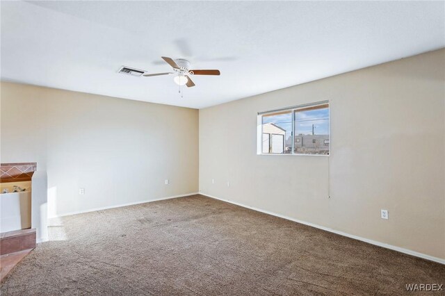 empty room with ceiling fan, carpet, visible vents, and baseboards