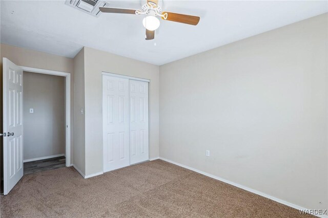 unfurnished bedroom with ceiling fan, carpet floors, visible vents, baseboards, and a closet