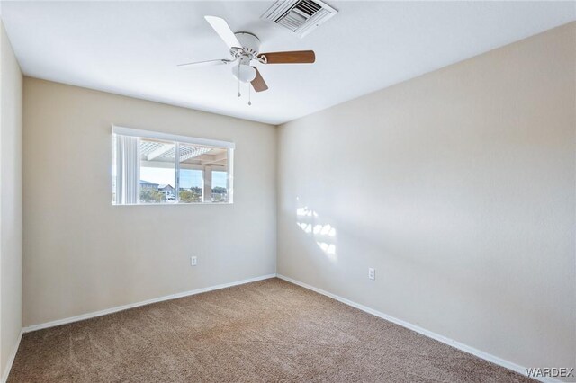 spare room with carpet floors, visible vents, ceiling fan, and baseboards