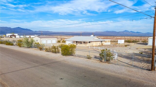 exterior space featuring an outdoor structure, fence, and a mountain view