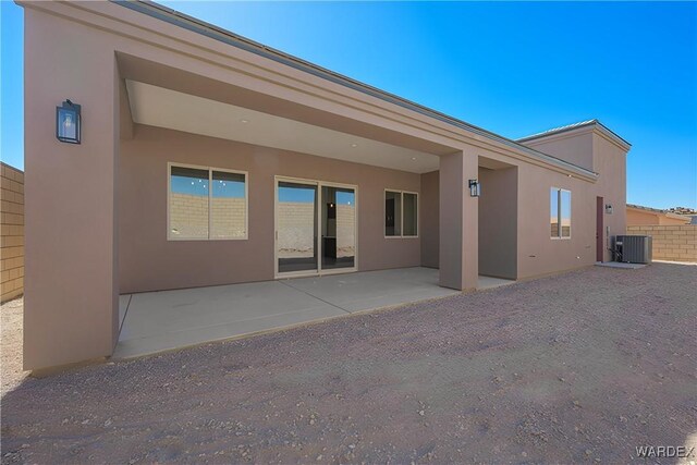 back of house with central air condition unit, a patio area, fence, and stucco siding