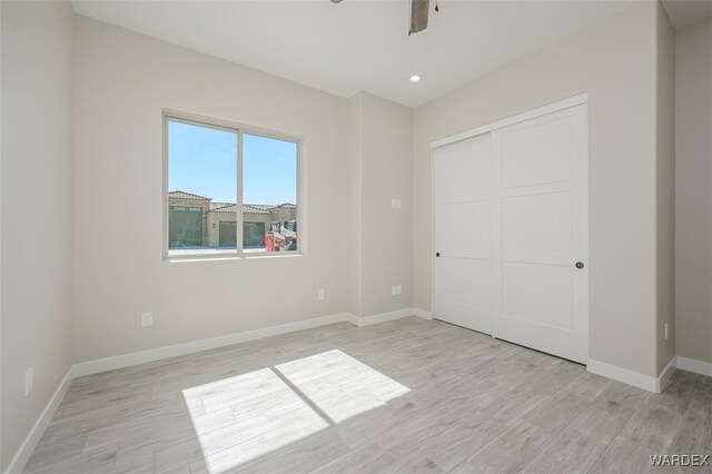 unfurnished bedroom with recessed lighting, a ceiling fan, baseboards, a closet, and light wood finished floors