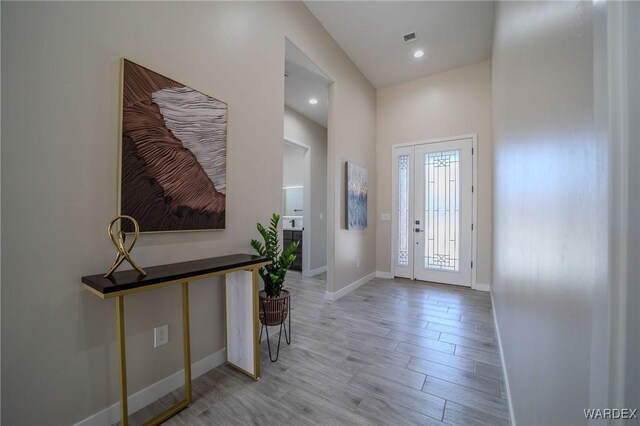 entryway with light wood-style floors, baseboards, visible vents, and recessed lighting