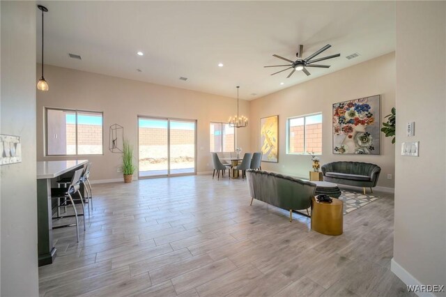 living room featuring light wood-style flooring, visible vents, baseboards, and recessed lighting