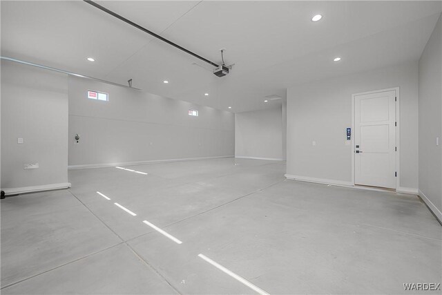 parking garage with recessed lighting and baseboards