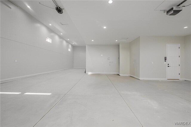 parking garage featuring baseboards, recessed lighting, and a garage door opener