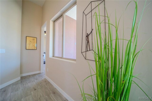 hallway featuring light wood-style floors and baseboards