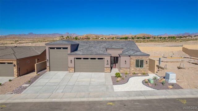 view of front of house featuring a garage, stone siding, concrete driveway, and stucco siding