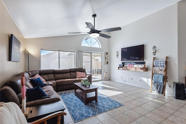 tiled living area with a ceiling fan and lofted ceiling