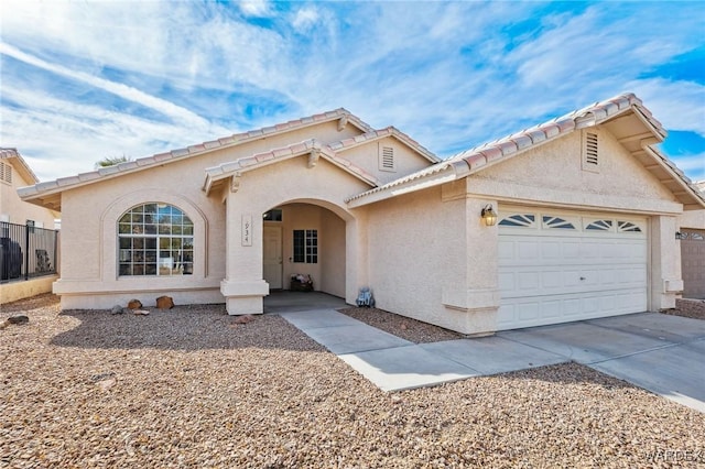 mediterranean / spanish-style house with concrete driveway, an attached garage, and stucco siding