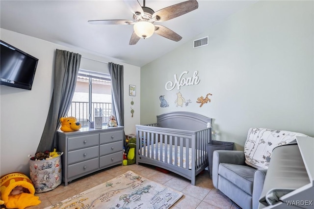 bedroom with light tile patterned floors, lofted ceiling, visible vents, a ceiling fan, and a crib