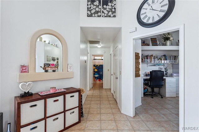 corridor featuring built in shelves, visible vents, and light tile patterned floors