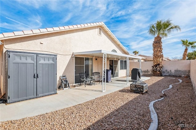 rear view of property featuring a patio, a fenced backyard, and stucco siding