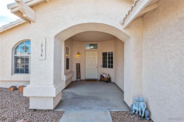 view of exterior entry featuring stucco siding