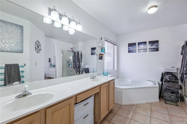 full bathroom featuring double vanity, a sink, a bath, and tile patterned floors