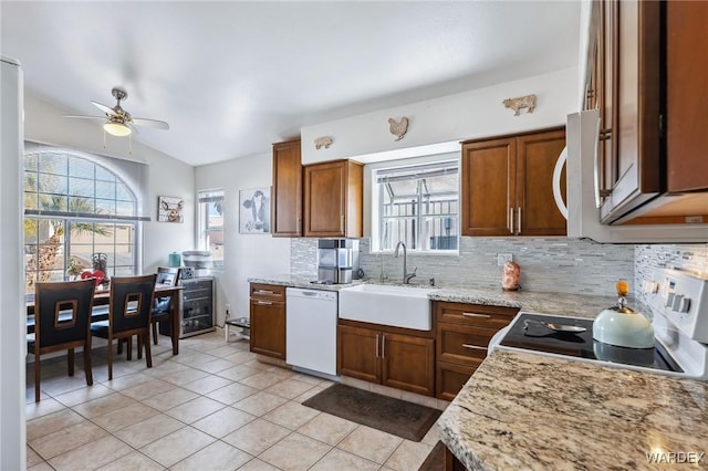 kitchen with a sink, tasteful backsplash, brown cabinetry, and dishwasher