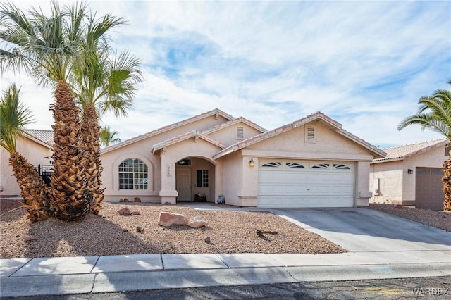 view of front of home featuring a garage, driveway, and stucco siding