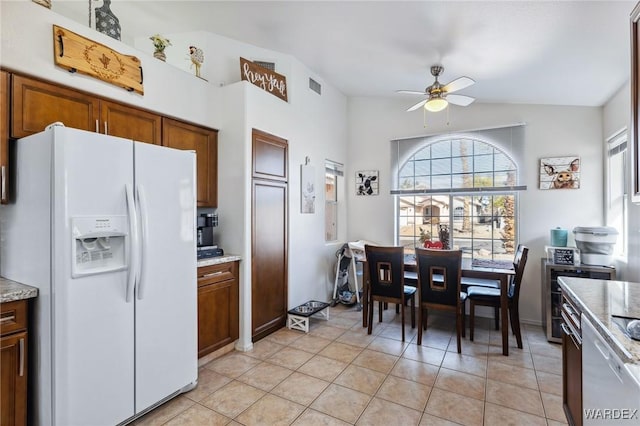 kitchen featuring white refrigerator with ice dispenser, visible vents, brown cabinets, and a ceiling fan