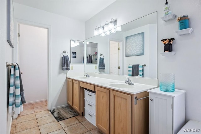 bathroom with tile patterned flooring, a sink, and double vanity