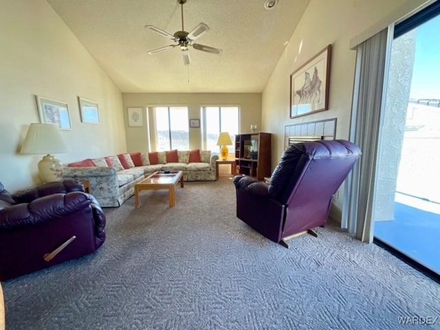 carpeted living area with a ceiling fan, vaulted ceiling, and a textured ceiling