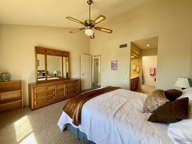 bedroom with ensuite bathroom, high vaulted ceiling, light colored carpet, a ceiling fan, and visible vents