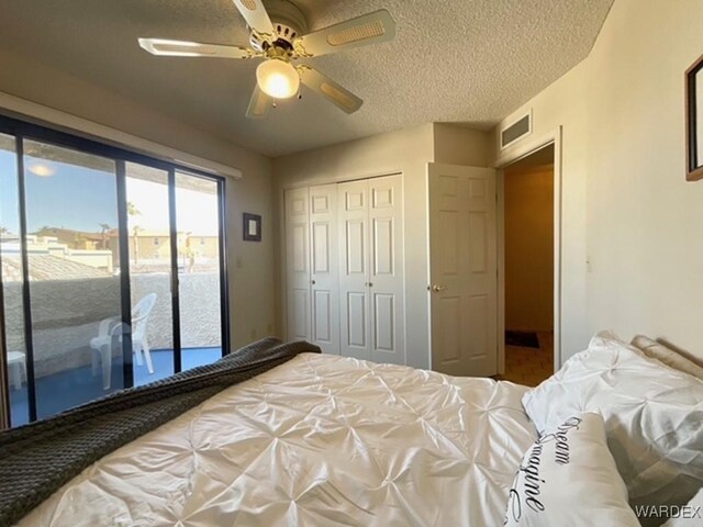 bedroom featuring access to exterior, a closet, visible vents, ceiling fan, and a textured ceiling