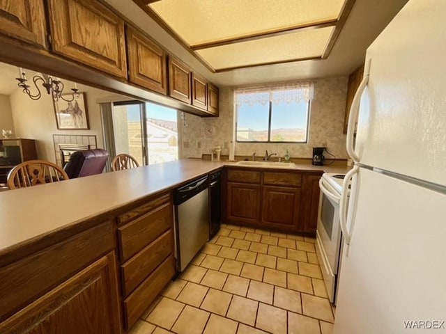 kitchen with electric range, dishwasher, freestanding refrigerator, a peninsula, and light countertops