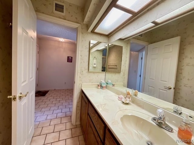 bathroom featuring wallpapered walls, tile patterned flooring, visible vents, and vanity