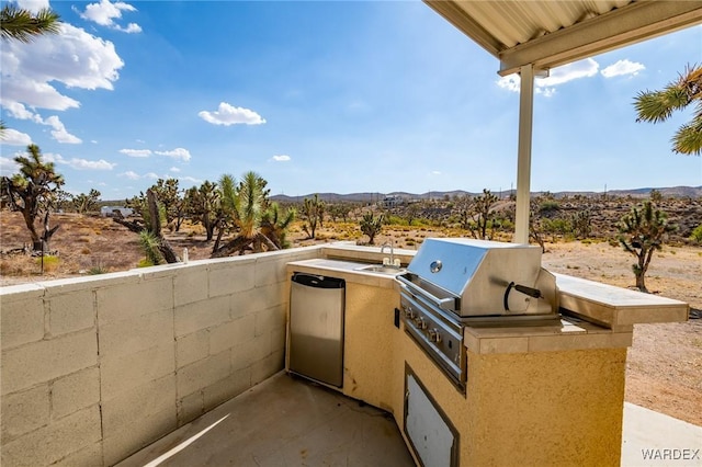 view of patio featuring exterior kitchen and a balcony