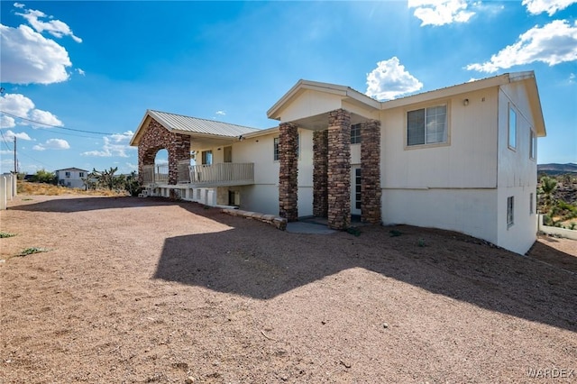 view of front of property featuring metal roof and driveway
